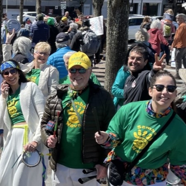 people outside on a sunny day taking part in a parade
