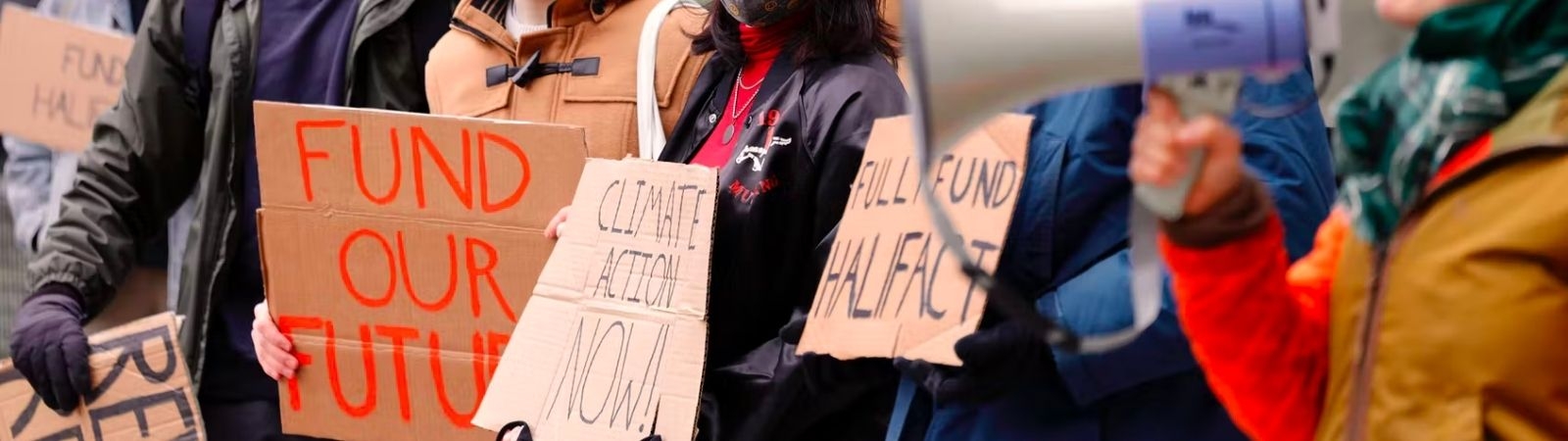 Teens holding protest signs against climate change