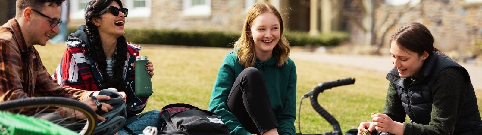 teens sitting on grass chatting