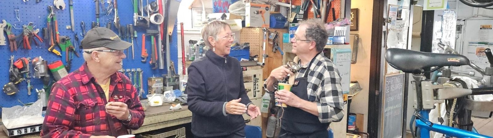 three senior adults volunteering in the bike shed