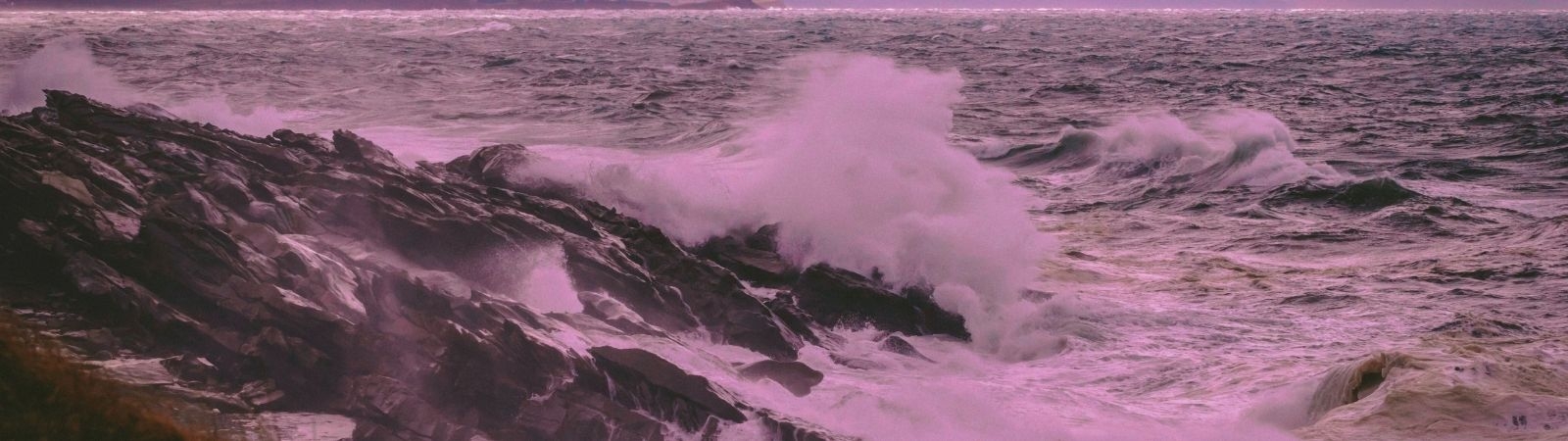 stormy waves crash against a rocky shore