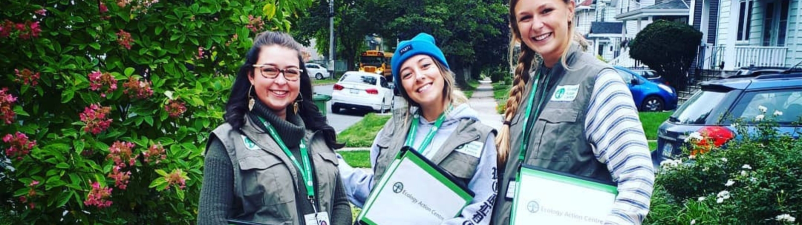 Three young canvassers smiling and holding clipboards