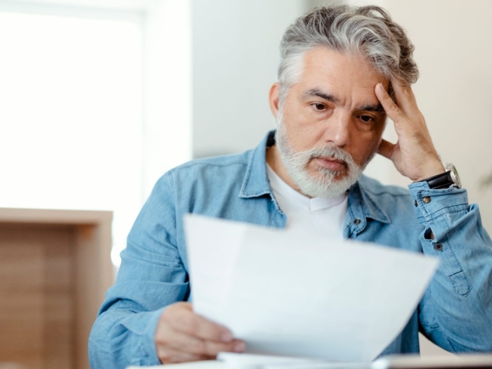 A man looks at an energy bill and is upset