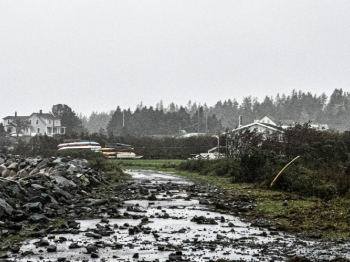 the sea spills over a seawall following a hurricane