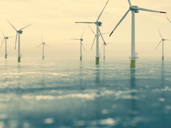 Offshore wind turbines with sun shining on the water