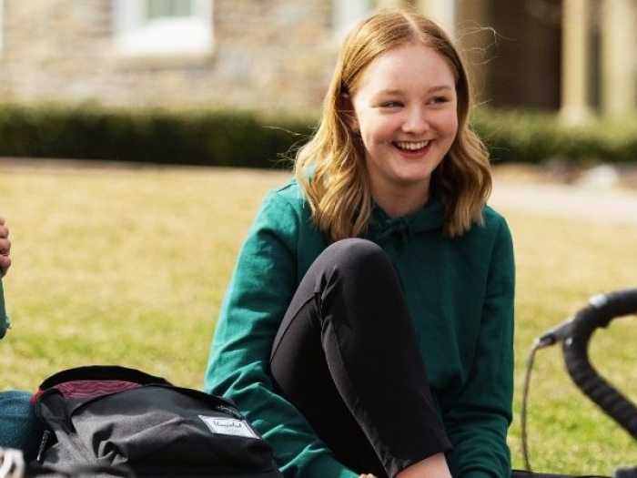 teens sitting on grass chatting