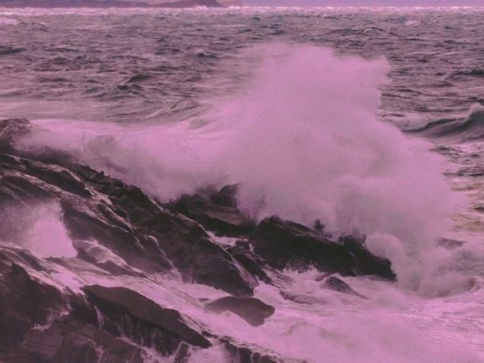 stormy waves crash against a rocky shore